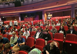 Uczniowie siedzą na widowni teatru.