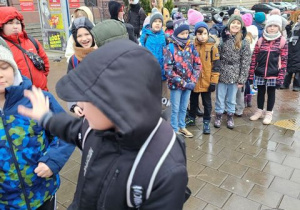 Uczniowie klas czwartych stoją przy Urzędzie.