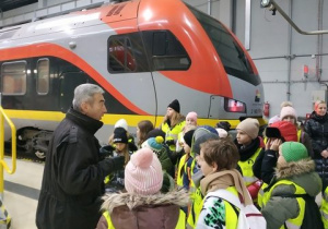 Grupa uczniów na tle pociągu