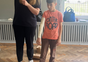 Pani Julia prezentuje bandażowanie kończyny górnej.