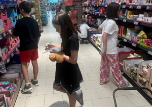 Uczniowie sprawdzają warunki zadania matematycznego podczas zakupów w sklepu.