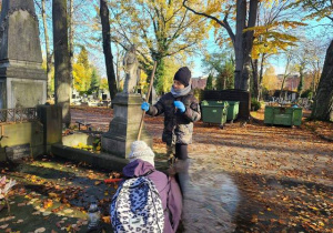 Uczniowie porządkujący groby na Starym Cmentarzu.