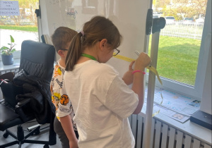 Matematyka w działaniu - uczniowie za pomocą miarki dokonują pomiarów w pracowni.