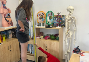 Para uczniów mierzących wysokość stojaka na mapy.