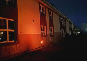 Podświetlenie budynku szkoły na czerwono jako symbol solidaryzowania się z przeciwdziałaniem przemocy w rodzinie.