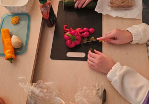 Uczniowie kroją produkty do kanapek.