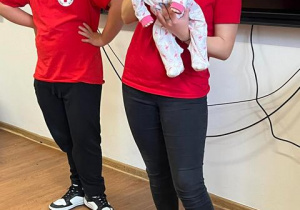 Wolontariusze z PCK wyjaśniają jak udzielać pomocy małemu dziecku.