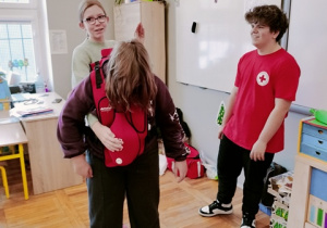 Uczniowie ćwiczą udzielanie pierwszej pomocy podczas zadławienia.