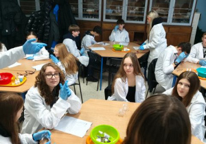 Uczniowie siedzący podczas zajęć z chemii.