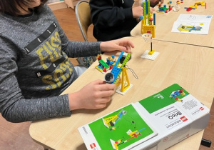 Klocki Lego w rękach uczniów.