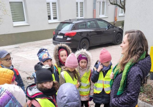 Grupa uczniów stoi przed budynkiem