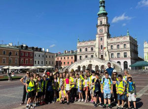 Uczniowie z klasy 5a i 5b na Rynku w Zamościu, w tle ratusz i kamieniczki.